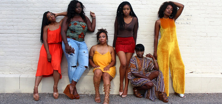 Sechs Frauen die an einer Wand lehnen